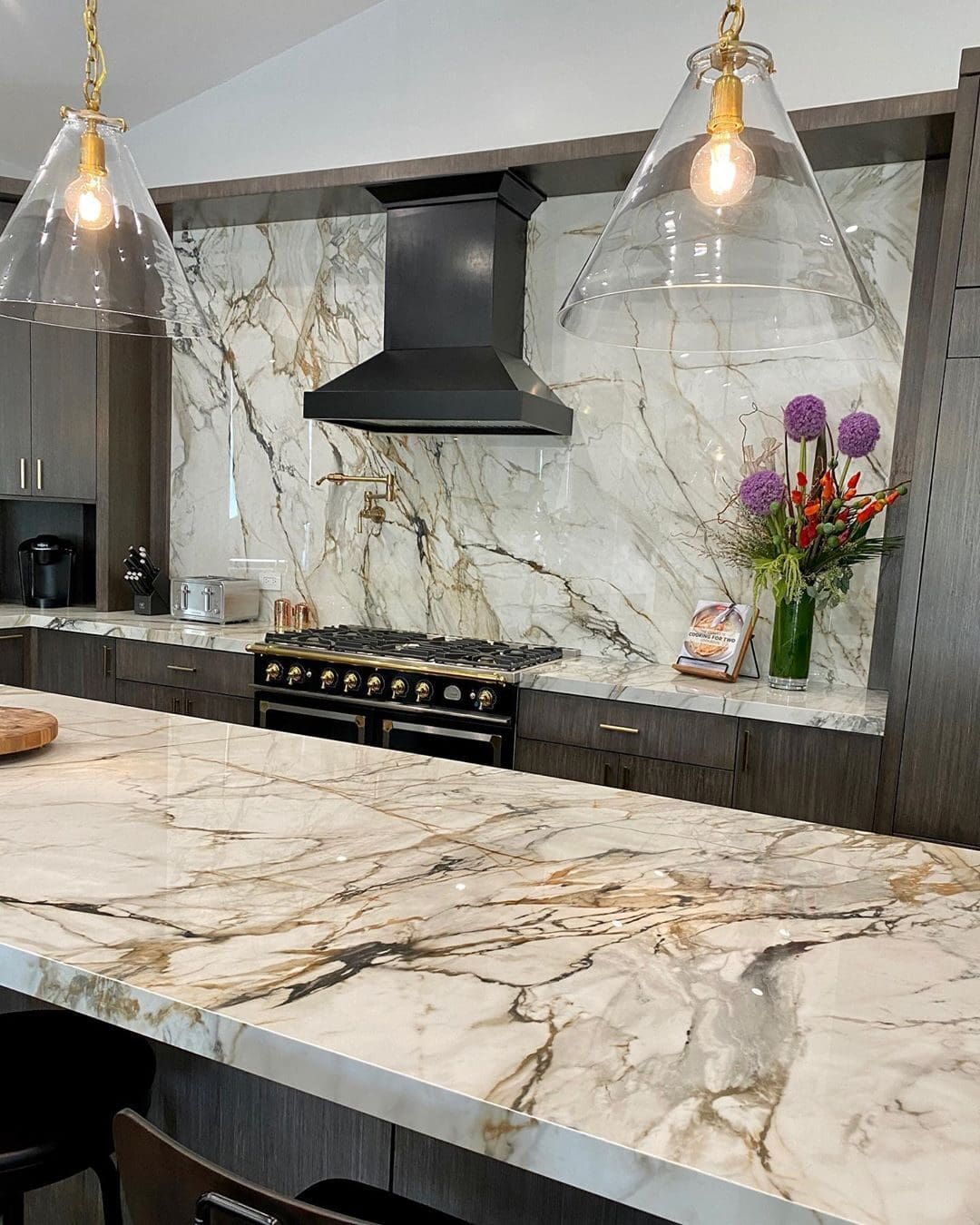 A kitchen with marble counter tops and an island.