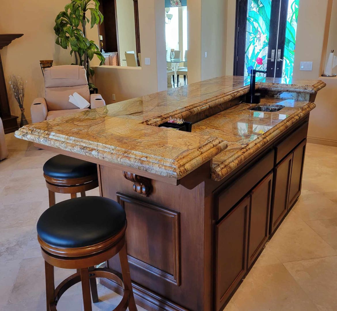 A kitchen island with two stools and a sink.