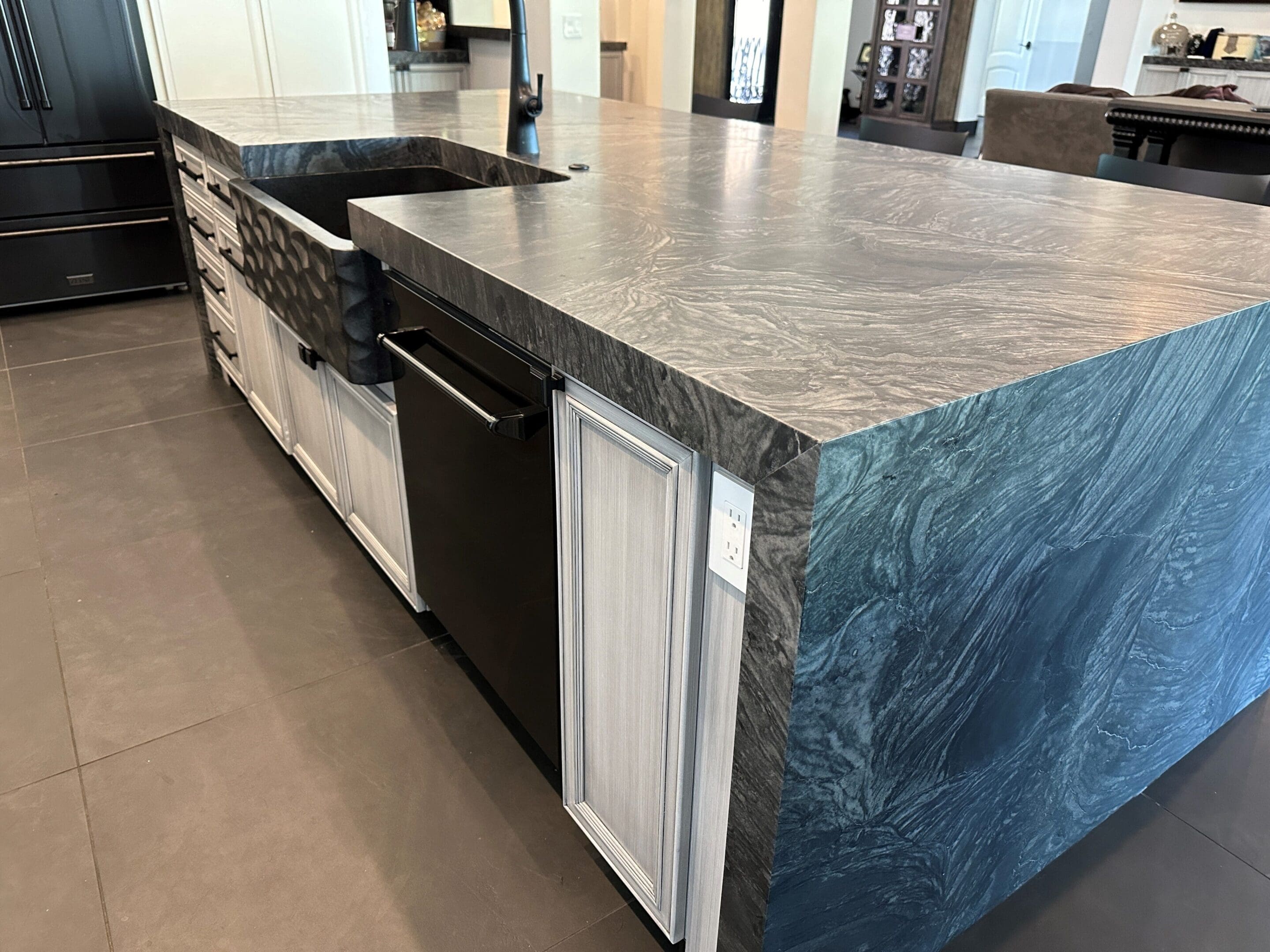 A kitchen with a large island and granite counter tops.